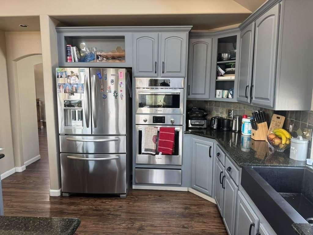 Open kitchen with gray cabinets and stainless appliances, ready for a move-in cleaning