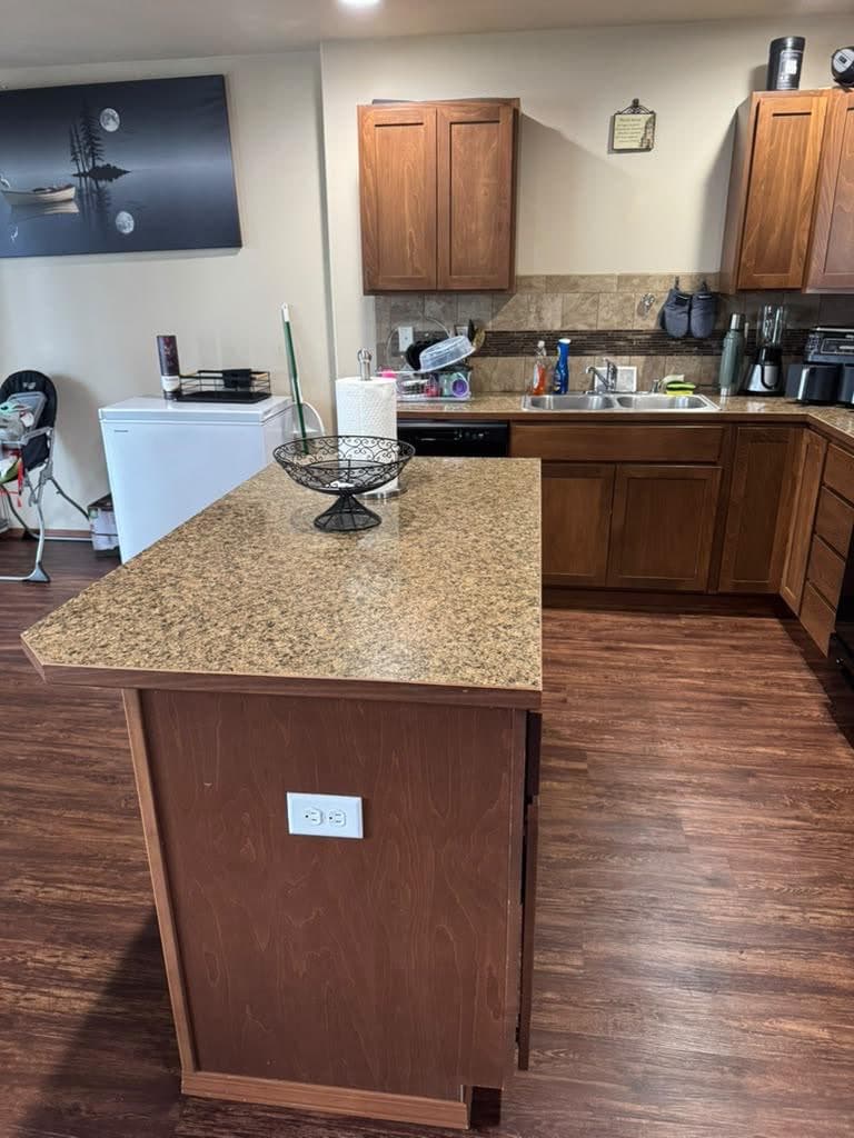 Gloved hand wiping down a kitchen counter during a standard cleaning visit